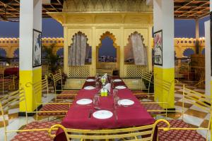 a dining room with a long table and chairs at Treebo Trend The Fresco Lake Pichola in Udaipur