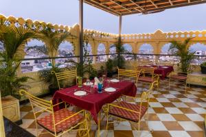 a restaurant with tables and chairs with a view of the city at Treebo Trend The Fresco Lake Pichola in Udaipur