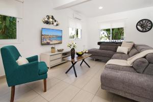 a living room with a couch and a chair at Nissi Sapphire Villa in Ayia Napa