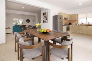a kitchen and dining room with a wooden table and chairs at Nissi Sapphire Villa in Ayia Napa