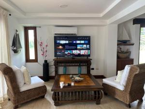 Golf Views Near Bayahibe & Casa De Campo في لا رومانا: غرفة معيشة مع طاولة قهوة وتلفزيون بشاشة مسطحة