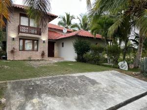 une maison avec des palmiers en face d'une allée. dans l'établissement Golf Views Near Bayahibe & Casa De Campo, à La Romana