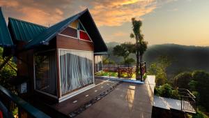 a house with a balcony with a view of the mountains at Vayalada View Point Resort in Kozhikode