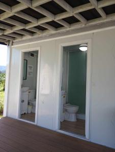 bagno con servizi igienici e 2 lavandini in una casa di North Shore Glamping / Camping Laie, Oahu, Hawaii a Laie