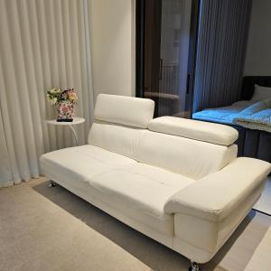 ein weißes Sofa in einem Zimmer mit einem Bett in der Unterkunft Domus in Seoul