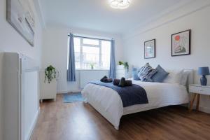 a white bedroom with a bed and a window at Lovely 2-bed Highbury Home in London
