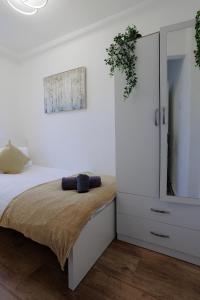 sypialnia z łóżkiem i białą szafką w obiekcie Lovely 2-bed Highbury Home w Londynie
