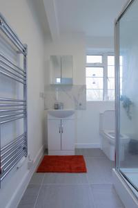La salle de bains blanche est pourvue d'un lavabo et de toilettes. dans l'établissement Lovely 2-bed Highbury Home, à Londres