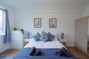 een slaapkamer met een groot bed en een blauwe deken bij Lovely 2-bed Highbury Home in Londen