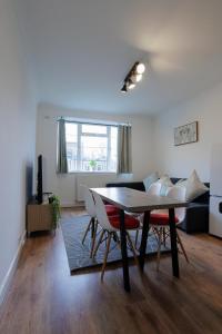 een woonkamer met een tafel en een bank bij Lovely 2-bed Highbury Home in Londen