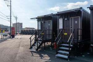 a group of tiny homes are parked in a parking lot at HOTEL R9 The Yard 荒尾 in Arao