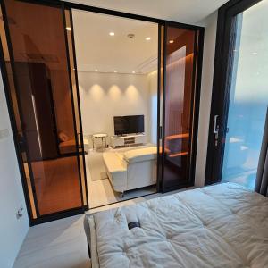 a bedroom with a bed and a room with a television at Domus in Seoul