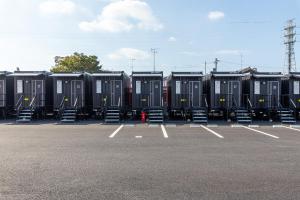 a parking lot with rows of black portable toilets at HOTEL R9 The Yard 荒尾 in Arao