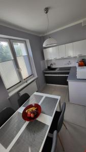 a kitchen with a table with a bowl of food on it at Apartamenty Motyl in Żywiec
