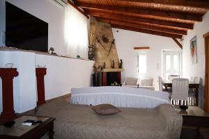 a bedroom with a bed and a table and a television at Villarosa Calma apartment in Stavros