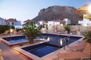 a pool at a hotel with a mountain in the background at Villarosa Calma apartment in Stavros