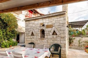 een patio met een tafel en een bakstenen oven bij Villarosa Calma apartment in Stavros