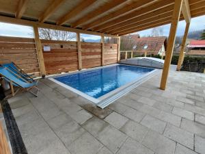 a swimming pool under a pergola on a patio at Švihák lázeňský in Velké Losiny