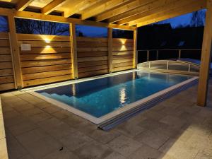 a swimming pool under a wooden pergola at Švihák lázeňský in Velké Losiny