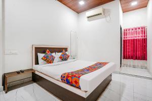 Schlafzimmer mit einem Bett und einem roten Fenster in der Unterkunft Via Sai Lodging I - Nr Nashik Railway Station in Nashik