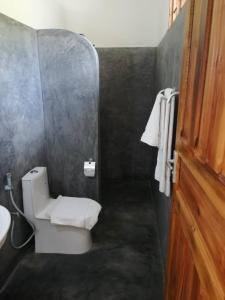 a bathroom with a white toilet and a sink at Zangreen Bungalows in Jambiani