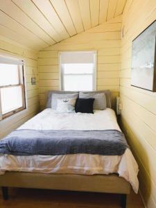 a bed in a small room with two windows at Cozy Beach - Direct Waterfront! in East Haven