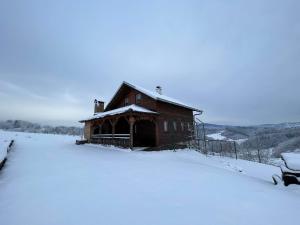 a snow covered cabin on a hill in the snow at Zagorska Klet in Gorjakovo