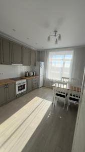 cocina con mesa, nevera y mesa en ЖК Ауэзова1 en Kokshetau