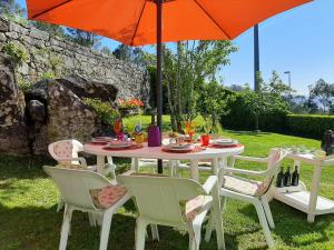 a table with an orange umbrella and chairs and a table at Casa Campo de Cortes in Muros