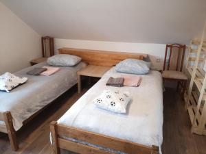 two twin beds in a room with two chairs at Small house in Celje in Celje