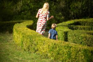 una mujer y un niño caminando por un seto en Château de Villarlong en Villarzel-Cabardès