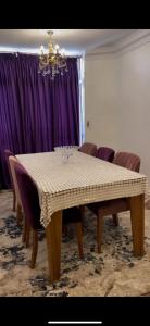 a dining room with a table and purple curtains at القاهرة مدينة نصر in Cairo