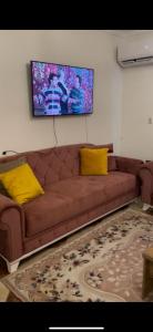 a brown couch with yellow pillows in a living room at القاهرة مدينة نصر in Cairo