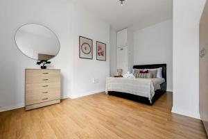 a bedroom with a bed and a mirror and a dresser at Spacious 1 bed flat close to Crouch End in London