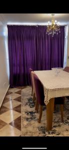 a dining room with a table and purple curtains at القاهرة مدينة نصر in Cairo