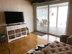 a living room with a flat screen tv and a couch at Cozy Beach - Direct Waterfront! in East Haven
