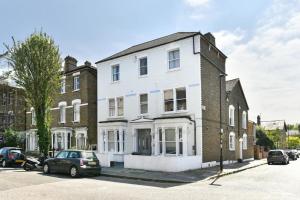 Spacious 1 bed flat close to Crouch End في لندن: مبنى ابيض فيه سيارات تقف امامه