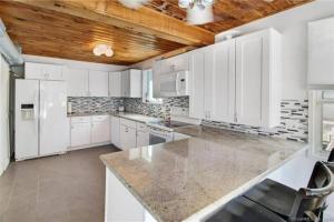 a kitchen with white cabinets and a wooden ceiling at Cozy Beach - Direct Waterfront! in East Haven