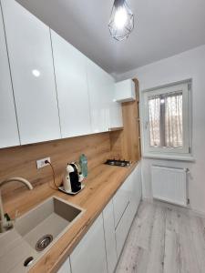 a kitchen with white cabinets and a sink and a window at Studio - Cozy Home Slatina in Slatina