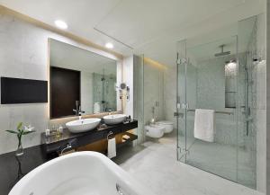 a bathroom with two sinks and a glass shower at Marriott Hotel Al Forsan, Abu Dhabi in Abu Dhabi