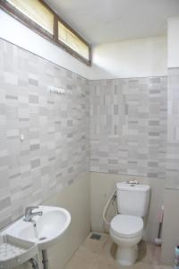 a bathroom with a toilet and a sink at Bracha house in Legian