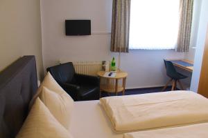 a hotel room with a bed and a chair and a table at Mittelrhein Pension in Boppard