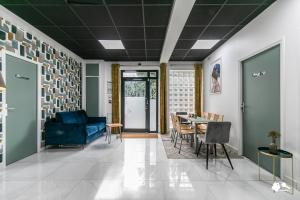 een woonkamer met een blauwe bank en een tafel bij MBA Splendide Appart - Girardot - Montreuil Centre in Montreuil