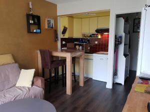 a living room with a table and a kitchen at Port plage a pied 3nuits mini in Le Pouliguen
