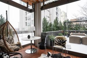 a room with a hammock and a balcony with windows at Luxorius apartment on the beach and the citycenter in Helsinki