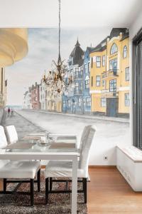 Luxorius apartment on the beach and the citycenter في هلسنكي: غرفة طعام مع طاولة و لوحة على الحائط