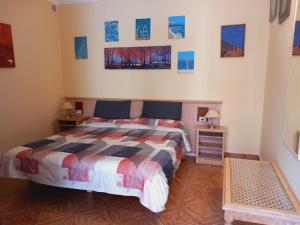 a bedroom with a bed and paintings on the wall at Casa Abora puro arte in Breña Alta