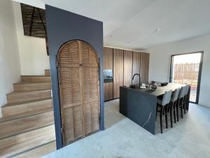 a kitchen with a wooden door leading to a table at Villa Nomade proche de Cannes in Vallauris