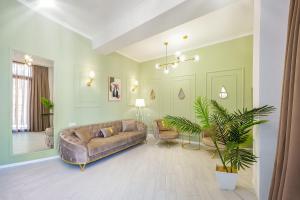 Una sala de estar con un sofá y una planta. en HB apartments Chikovani, en Tiflis