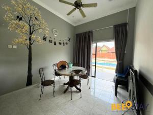 a dining room with a table and chairs and a tree at Melaka Afamosa DAmour Villa 12PAX with Private Pool & BBQ in Kampong Alor Gajah